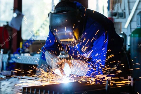 Soldador trabajando en estructura de acero de gran tamaño